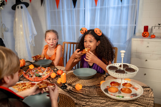 Multiracial family celebrating Halloween party together in house. 