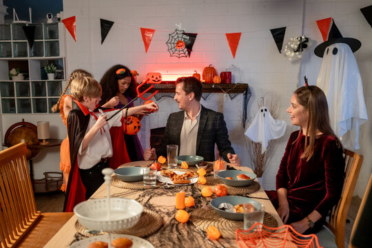 Multiracial family celebrating Halloween party together in house.