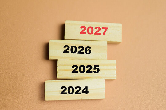 Concept of 2024, 2025. 2026, 2027 text on wooden blocks. For the beginning of the new year, new goals and next decade