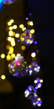Hanging transparent Christmas balls with glowing LED lights.
