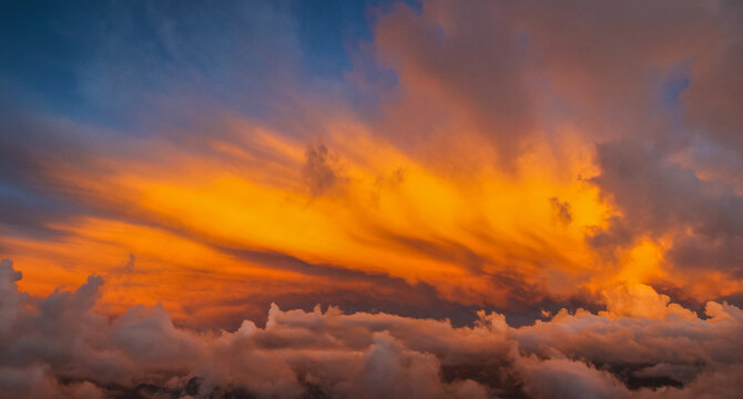 Fiery orange sunset clouds above the horizon