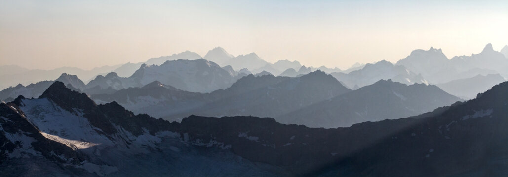 Hazy blue mountain range layers with snow capped peaks