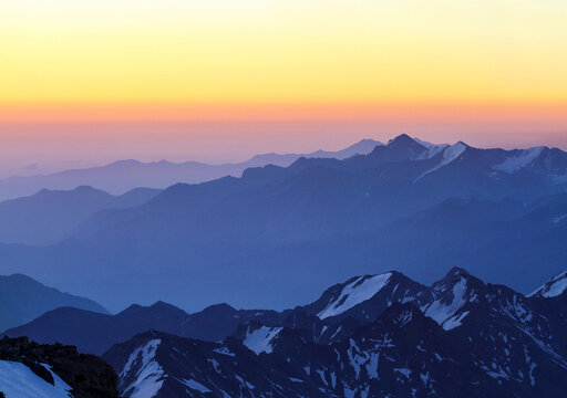Blue mountain layers under a golden orange sky