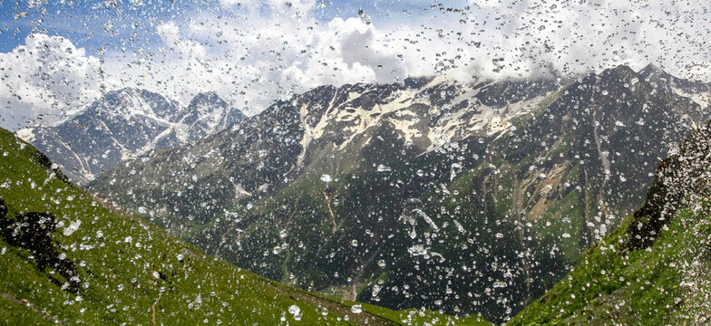 Splashing water droplets with a mountain valley background