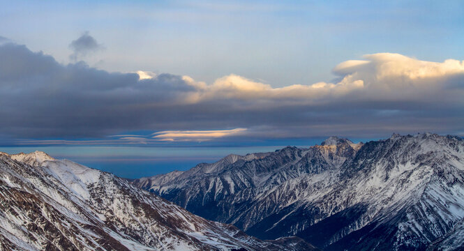 Lenticular clouds over a vast snowy mountain range