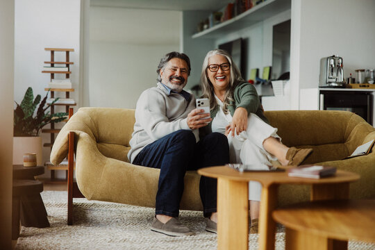 Senior couple relax with a cell phone in their living room