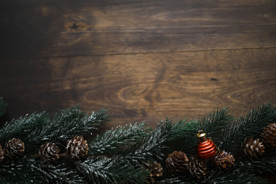 Christmas background with fir tree and decoration on dark wooden board