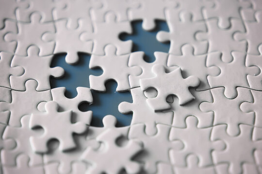 Clean puzzle elements on the red background. Empty puzzle piece on the table. Teamwork concept.