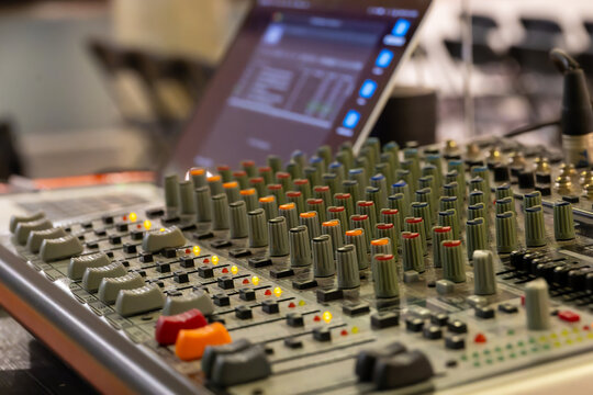 Professional audio mixing console with knobs and faders in a recording studio