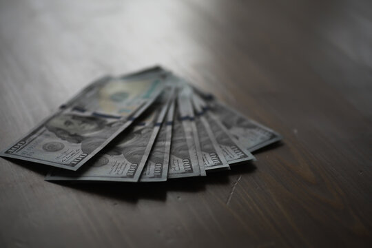 Stack of US Dollar Bills on Wooden Surface Reflecting Wealth and Financial Security