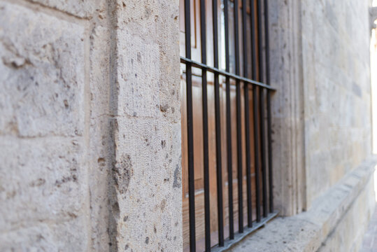 Ancient Stone Wall with Iron Window Bars and Historic Architecture
