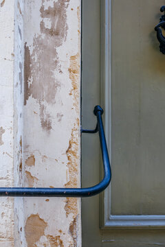 Green Wooden Door and Black Metal Handrail Detail, Weathered Painted Panels, Limestone Wall Texture