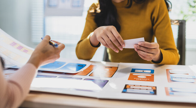 UX UI designers collaborating on mobile app wireframes.