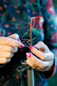Hands thread fishing line through lure
