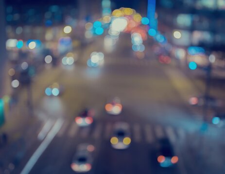 Blurred night city street traffic with bokeh lights from cars and buildings