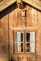 Rustic wooden croft with window and birdhouse © Lars Johansson