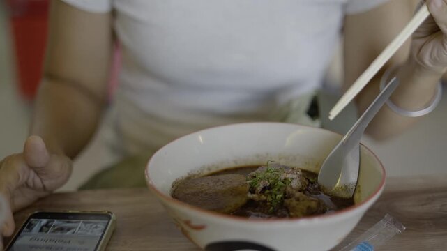 Woman Enjoying Delicious Traditional Noodle Soup