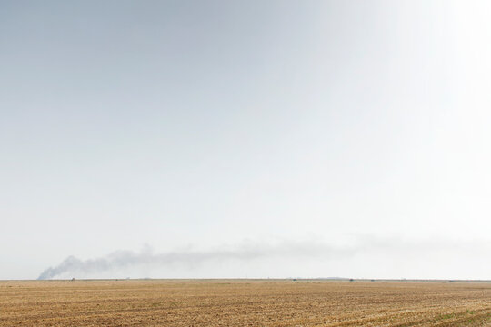 Harvested Field With Hay Bales And Farm Truck Under Expansive Overcast Sky
