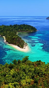 Aerial view of Port Barton Beach with white sand, lush tropical vegetation, and turquoise coral reef waters in Mimaropa, Philippines.