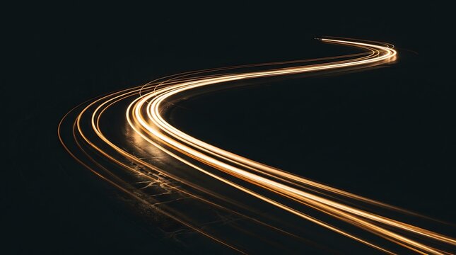 Long exposure light trails of cars moving along a winding road at night, creating a dynamic sense of motion and speed against a dark background