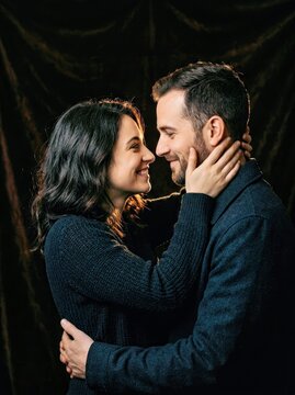 Couple in an Embrace Black Attire Warm Lighting