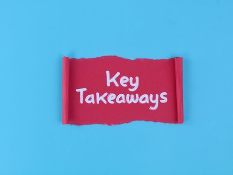 Key takeaways text handwritten on a red paper scroll against blue background. Perfect for business presentations, summaries, education, and learning concepts