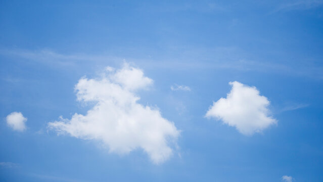 Minimalist bright blue sky with fluffy white cumulus clouds