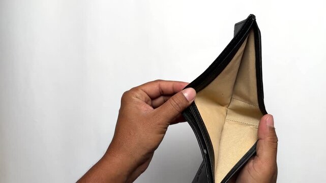 Hands opening empty leather wallet with no money on white background
