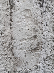 White rough stucco wall texture with plaster repair patch, grunge background © Deri