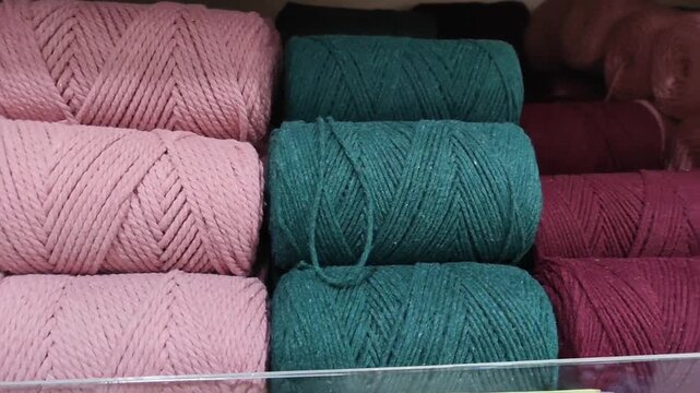 Colorful spools of thick macrame cord neatly arranged on a store shelf, durable cotton rope for knitting and handcrafting