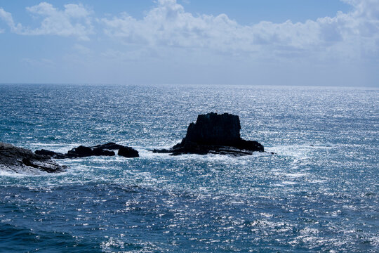 Dramatic Sea Stack in Open Ocean under Blue Sky