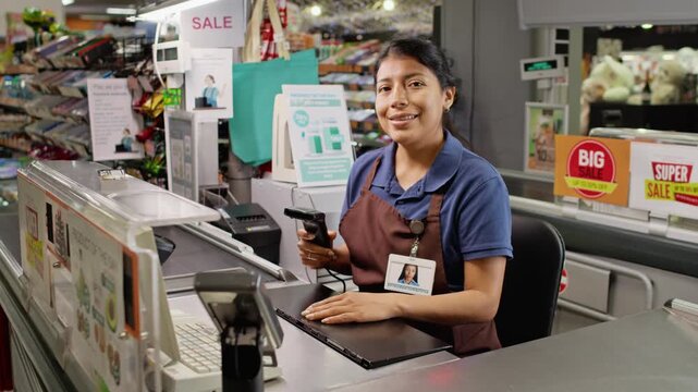 Portrait of smiling young adult Hispanic woman cashier holding barcode scanner at supermarket checkout. Ideal for retail customer service training, grocery store advertising, and corporate videos