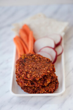 Vegetarian bean burgers with carrot sticks and radish slices