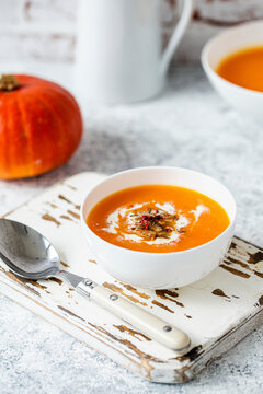 Pumpkin cream soup with cream swirl and peppercorn garnish
