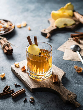 Apple punch with cinnamon and apple slice on wooden board