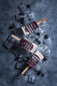 Blueberry creamy popsicles on ice cubes