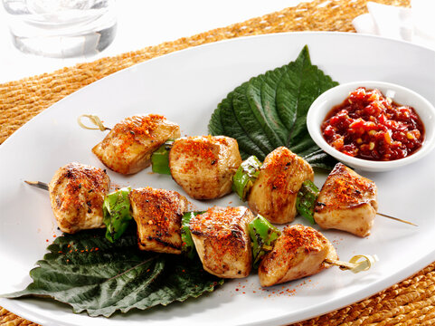 Yakitori spiced grilled chicken skewers on Perilla leaves with chili
