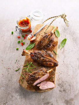 Mini pork knuckles with pepper cream sauce on wooden cutting board