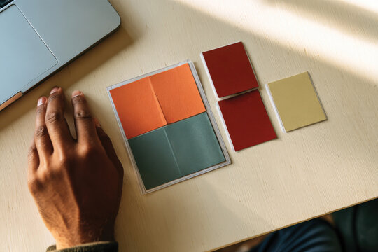 An organized display of colorful notepads and sticky notes next to a laptop, showcasing an aesthetically pleasing workspace filled with creativity and color.