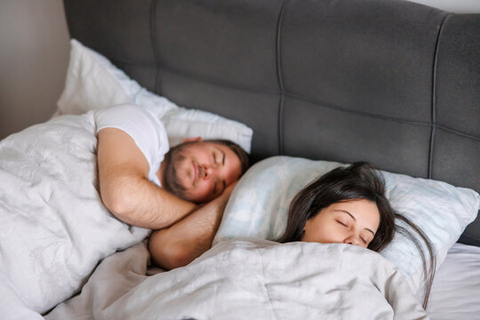 Couple sleeping in bed at home in the morning