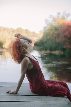 Redhead woman enjoying peaceful autumn river day