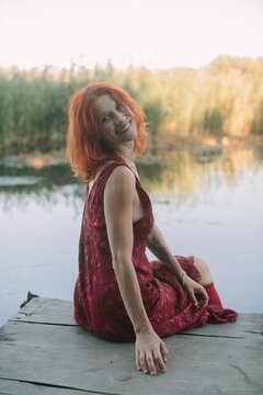 Woman with red hair smiling on wooden pier