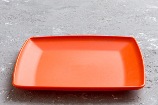Perspective view of empty square plate on cement background. Empty space for your design