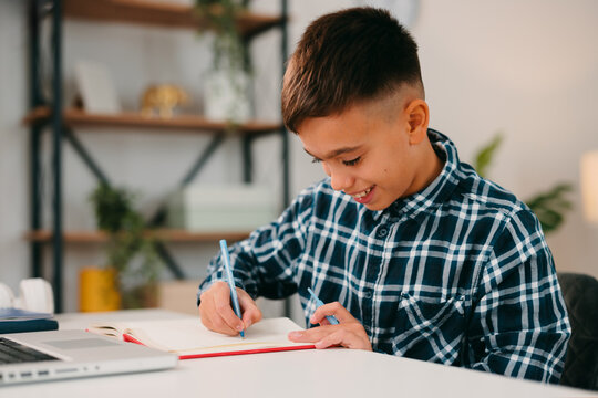 Young boy learning studying homework writing on notebook