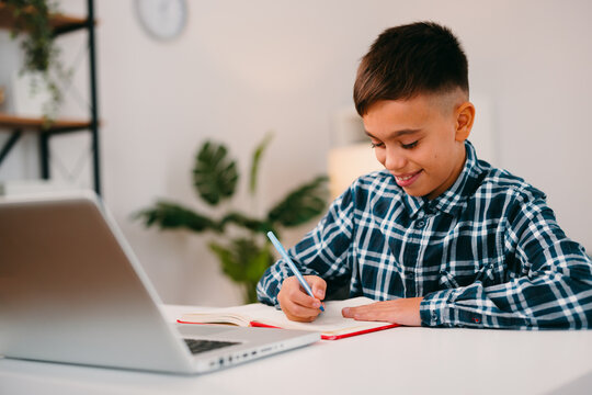 Student boy learning studying homework online with laptop