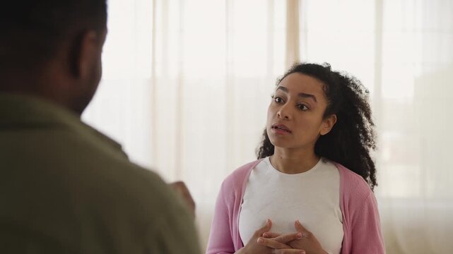 Displeased young Black woman shouting at husband at home, relationship crisis