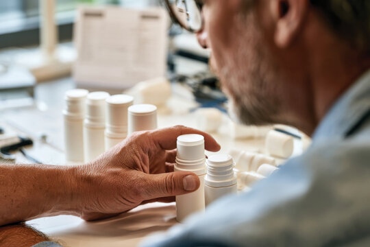 A person intently focused on arranging products on a workspace table, symbolizing order and attention to detail in a product management context.