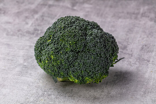 Grey stone surface, fresh green broccoli head, raw vegetable