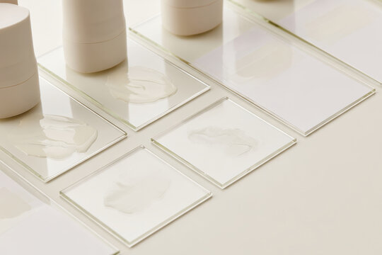 An artistic presentation of different creams displayed on glass plates, capturing the textured beauty and variety of skincare products available for personal grooming.
