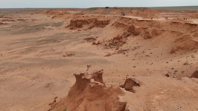 aerial view of red clay ridges, steep canyons, and vast desert plains characteristic of the prehistoric Flaming Cliffs region in the Gobi Desert, Mongolia.